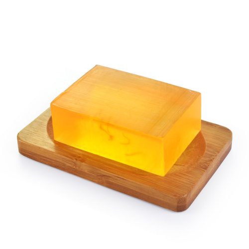 A bar of soap resting on a wooden tray, showcasing a natural and minimalist aesthetic.